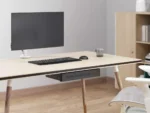 Minimalist office setup with small metal drawer mounted under the table.