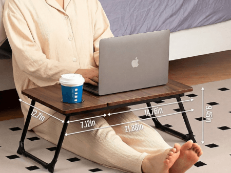 Woman using portable bed table for writing, laptop work, and eating breakfast.